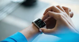 Whoop 5.0 Review 2026: Is the Subscription Worth It? Person clicking Apple Watch