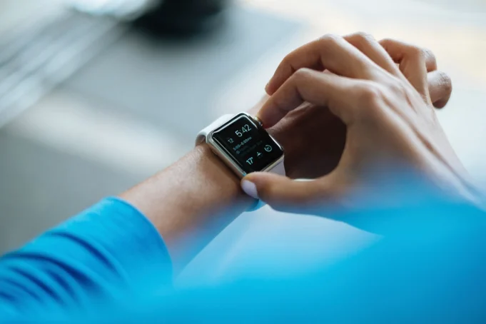 Whoop 5.0 Review 2026: Is the Subscription Worth It? Person clicking Apple Watch
